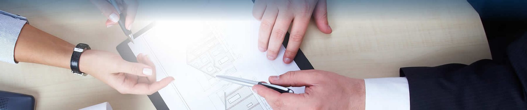 Manos revisando un plano t&eacute;cnico sobre una mesa de trabajo